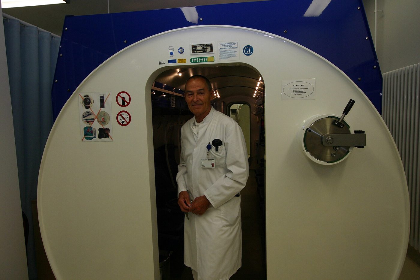 Neurolog Dietmar Schneider berdiri di dekat sebuah chamber hiperbarik.